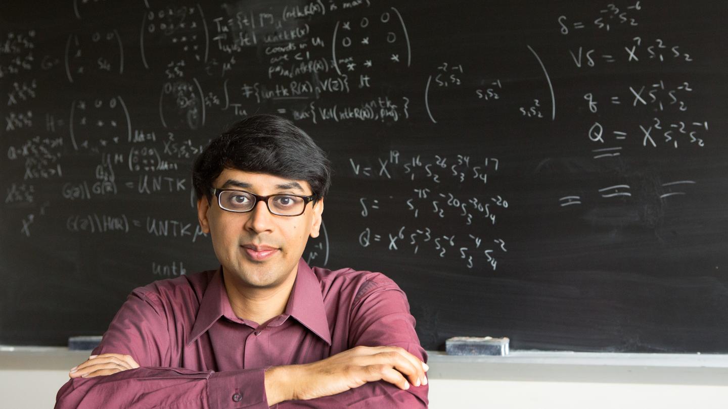 Faculty sitting near chalkboard