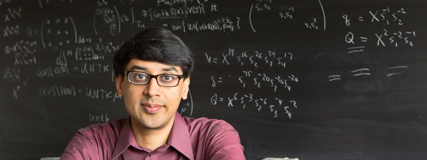 Faculty sitting near chalkboard